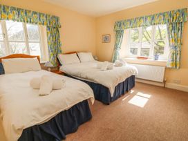 A bedroom with two beds and towels on top at Tremorla in Boscastle
