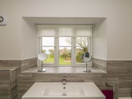A bathroom with a sink and mirrors at Tremorla in Boscastle