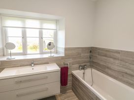 A bathroom with a bathtub and sink at Tremorla in Boscastle
