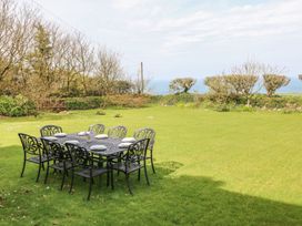 A garden with a table and chairs overlooking the sea at Tremorla in Boscastle