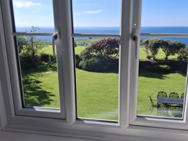 A view through a window showing a garden and sea at Tremorla in Boscastle