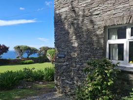An exterior view of a stone wall with a sign at Tremorla in Boscastle