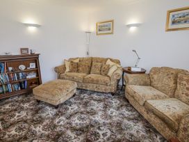 A living room with a sofa and bookshelf at No.1 Vanderhoof Way, Saundersfoot