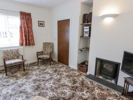 A living room with chairs and a television at No.1 Vanderhoof Way in Saundersfoot