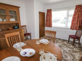 A dining room with a wooden table and chairs at No.1 Vanderhoof Way Saundersfoot