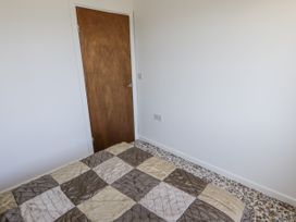 A bedroom with a bed and door at No.1 Vanderhoof Way Saundersfoot