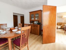 A dining room with a wooden table and chairs at No.1 Vanderhoof Way Saundersfoot