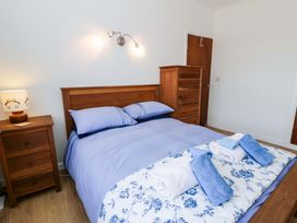 A bedroom with a bed and bedside lamp at No.1 Vanderhoof Way Saundersfoot