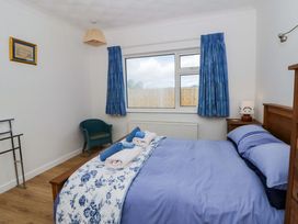 A bedroom with a bed and armchair at No.1 Vanderhoof Way in Saundersfoot