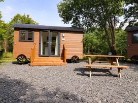 An outdoor area with a tiny house and a picnic table at Shepherds Hut 1