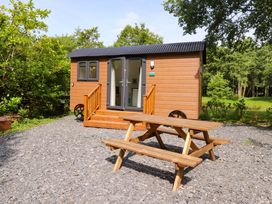 A cabin with a picnic table outside at Shepherds Hut 1