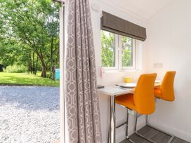 A dining area with a table and chairs at Shepherds Hut 1