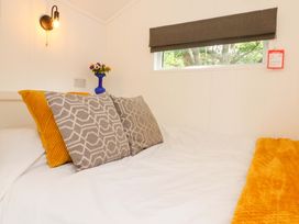 A bedroom with pillows and a blanket on a bed at Shepherds Hut 1