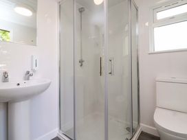 A bathroom with a shower, sink, and toilet at Shepherds Hut 1