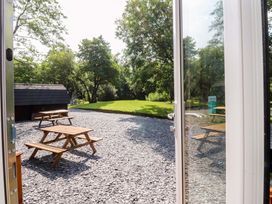 An outdoor area with picnic tables and a shed at Shepherds Hut 1
