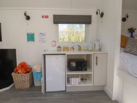 A kitchen area with refrigerator, microwave, and kettle at Butterfly Hut 1 Forton near Garstang