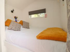 A bedroom with a bed and flowers on a table at Butterfly Hut 1 in Forton near Garstang