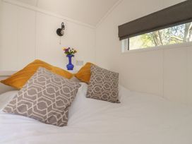 A bedroom with a bed and decorative pillows at Butterfly Hut 1, Forton near Garstang