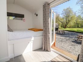 A bedroom with a bed and an open window at Butterfly Hut 1 Forton near Garstang