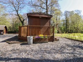 A wooden cabin with a deck and flower box at Butterfly Hut 1 Forton near Garstang