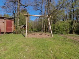 A swing set in a garden with trees at Butterfly Hut 1 Forton near Garstang