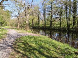A path next to a body of water surrounded by trees at Butterfly Hut 1 Forton near Garstang