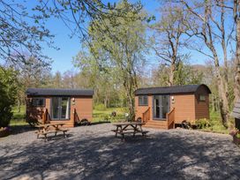 Two cabins with picnic tables in an outdoor area at Butterfly Hut 1 Forton near Garstang
