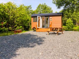 A shepherd's hut with outdoor seating at Shepherds Hut 2
