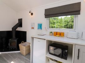 A kitchen with a wood stove and appliances at Shepherds Hut 2