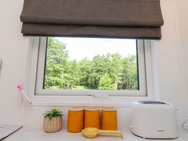 A kitchen window with storage jars and a toaster at Shepherds Hut 2
