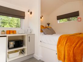 A bedroom with a bed and kitchen appliances at Shepherds Hut 2