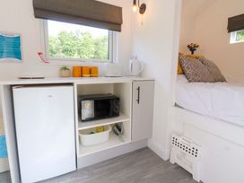 A bedroom with a fridge and microwave at Shepherds Hut 2