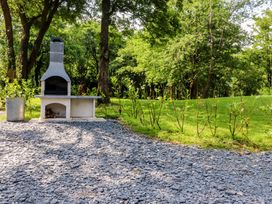A grill area with gravel and surrounding greenery at Shepherds Hut 2 