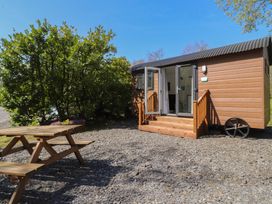 An outdoor view of a cabin with a table and benches at Butterfly Hut 2 Forton near Garstang