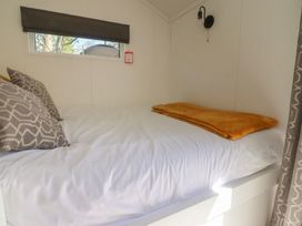 A bed with pillows and a blanket in a bedroom at Butterfly Hut 2 Forton near Garstang