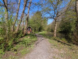 A path beside a river with trees and a cabin at Butterfly Hut 2 Forton near Garstang
