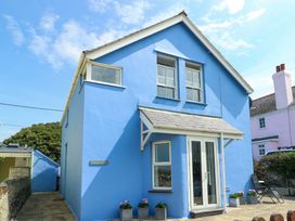 A blue house with windows and a door at Trwst Y Don Rhosneigr