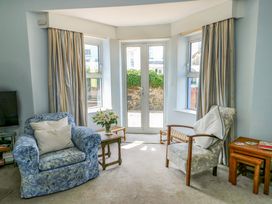 A living room with armchairs and a table at Trwst Y Don Rhosneigr