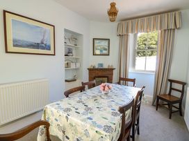 A dining room with a table and chairs at Trwst Y Don Rhosneigr