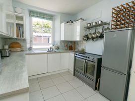 A kitchen with sink, oven, and refrigerator at Trwst Y Don in Rhosneigr