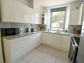 A kitchen with appliances and utensils at Trwst Y Don Rhosneigr