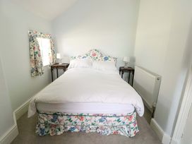 A bedroom with a bed and bedside tables at Trwst Y Don in Rhosneigr