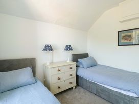 A bedroom with two beds and a chest of drawers at Trwst Y Don in Rhosneigr
