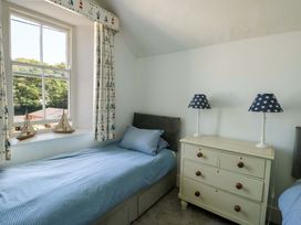 A bedroom with two single beds and a window at Trwst Y Don in Rhosneigr
