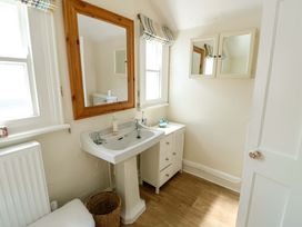 A bathroom with sink and mirror at Trwst Y Don in Rhosneigr