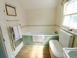 A bathroom with a bathtub and towel rack at Trwst Y Don in Rhosneigr
