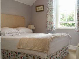 A bedroom with a bed and a window at Trwst Y Don in Rhosneigr