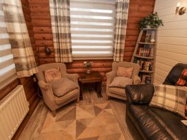 A snug with armchairs and a table at Farnes Lodge in Longframlington