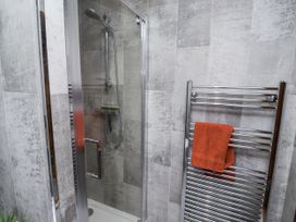 A shower enclosure with glass doors in a bathroom at Farnes Lodge Longframlington