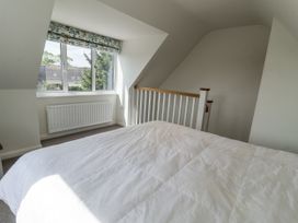 A bedroom with a bed and window at The Annex next to St Johns Southwold